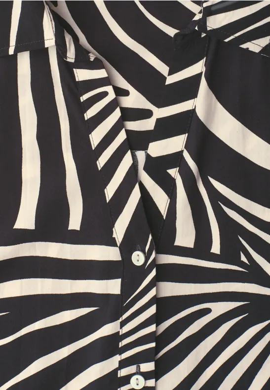 Zwart-witte zebraprint blouse met witte knopen.