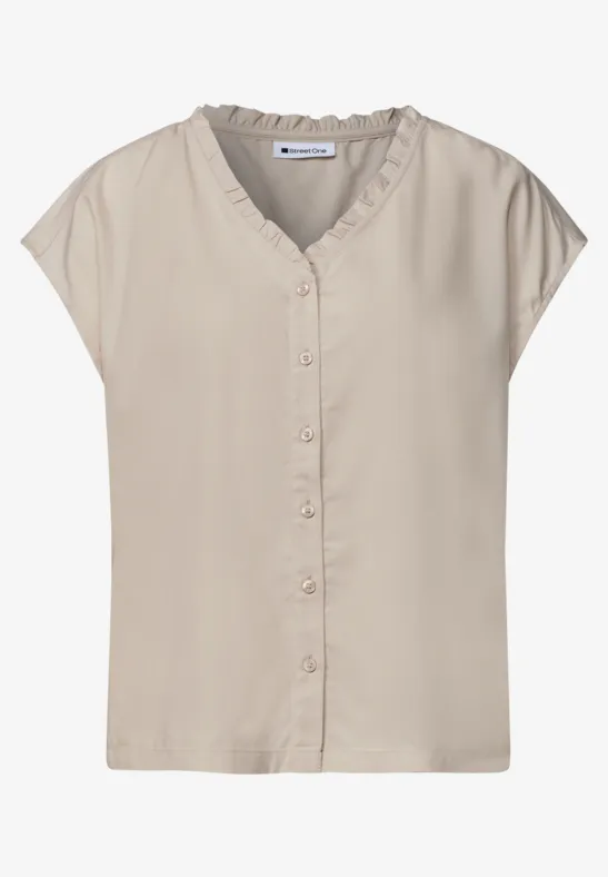 Beige mouwloze blouse met V-hals en knoopsluiting, losvallend model.