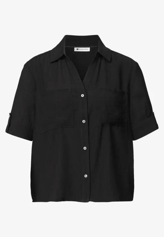 Schwarze, kurzärmlige Bluse mit Hemdkragen, Knopfleiste und Brusttaschen.