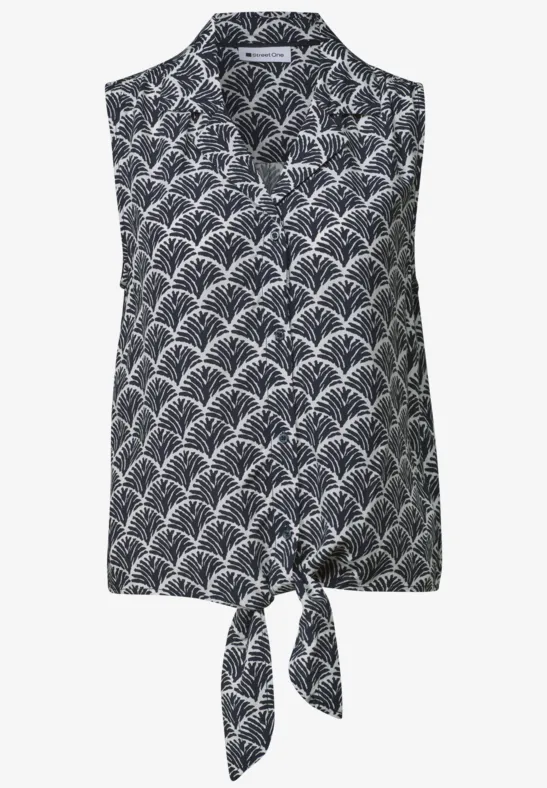 Mouwloze marineblauwe blouse met kraag, wit schelpenpatroon en knoopsluiting vooraan.