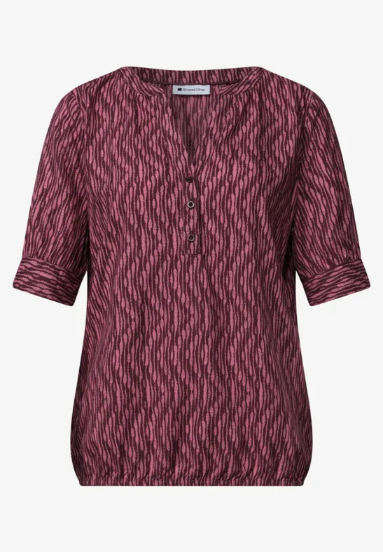 Rosa-schwarze, kurzärmelige Damenbluse mit V-Ausschnitt und Zickzackmuster.