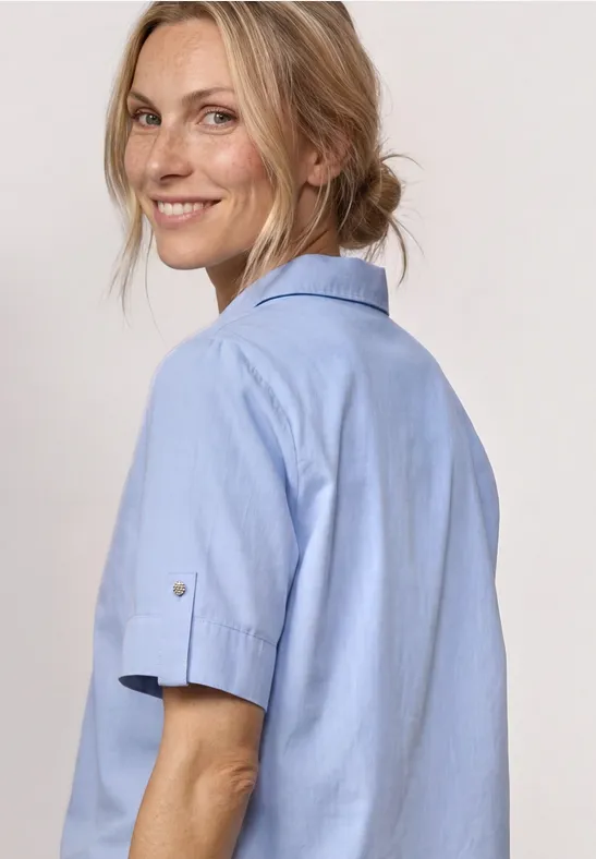 Vrouw in lichtblauwe korte mouwblouse, zijaanzicht