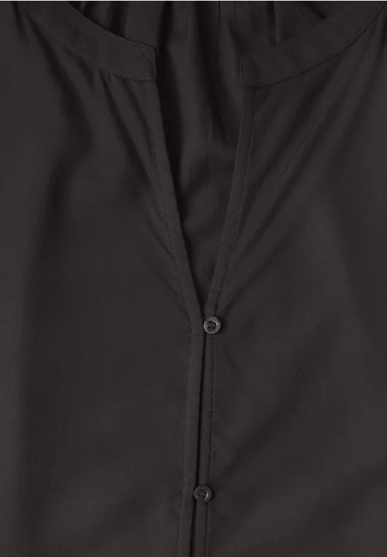 Haut noir à encolure en V avec deux petits boutons.