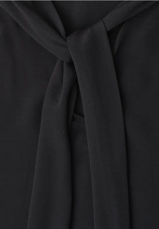 Tissu noir drapé en un nœud élégant