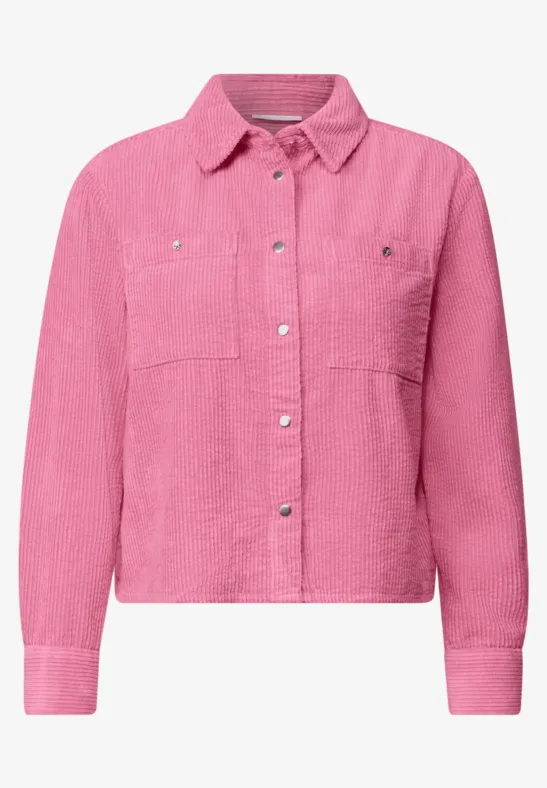 Veste-chemise rose en velours côtelé avec col chemise, poches poitrine et boutons-pression argentés.