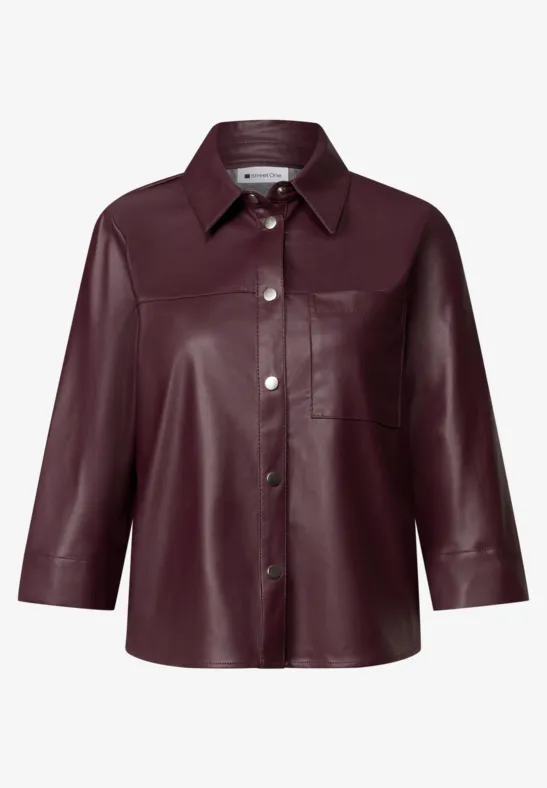 Bordeauxrood leren blouse met 3/4-mouwen, klassieke kraag, knoopsluiting en borstzak.
