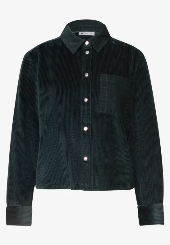 Veste-chemise en velours côtelé foncé avec poche poitrine, col classique et fermeture à boutons.