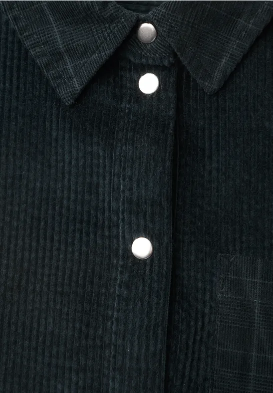 Chemise en velours côtelé sombre avec col et boutons argentés sur le devant.