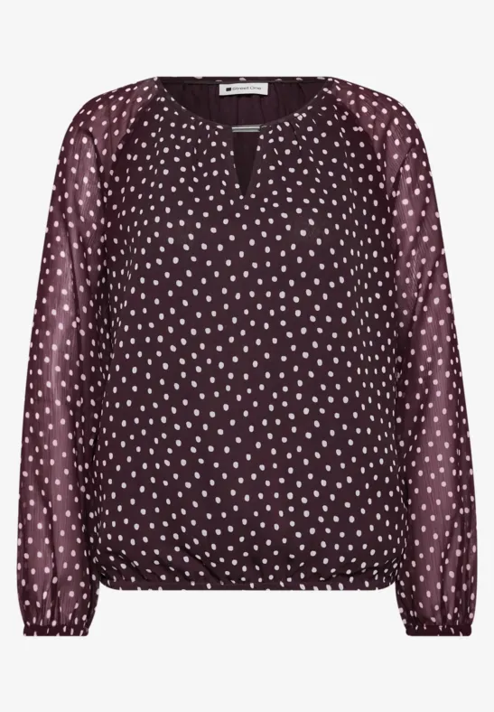 Blouse bordeaux à pois blancs, manches longues, encolure en V et taille élastiquée.