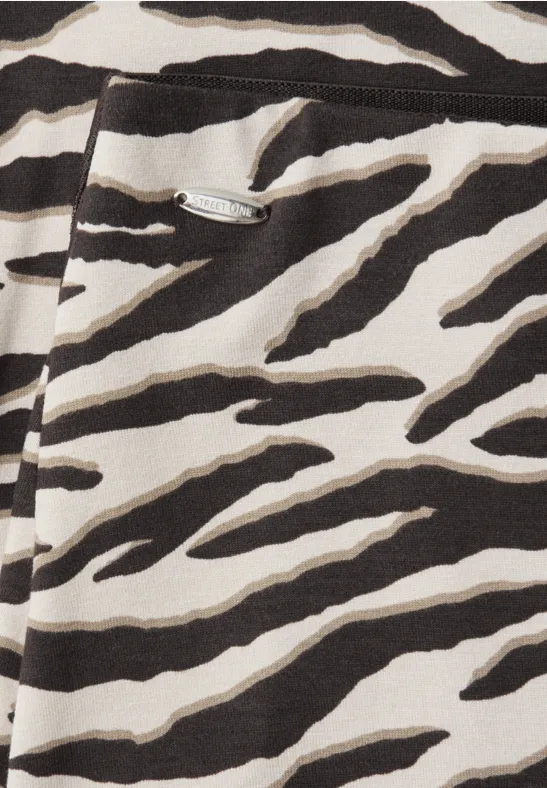 Gros plan sur un textile à motif zèbre noir et blanc, avec détail de fermeture éclair.