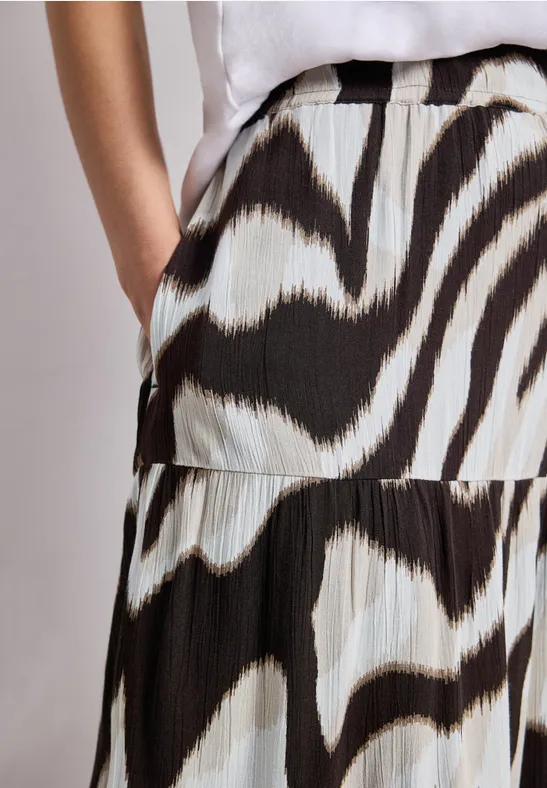 Wit-zwarte geplooide rok met zebraprint, hand in de zak, wit topje