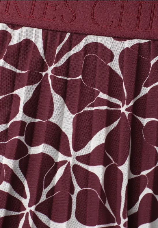 Weinroter Stoff mit weißem, organischem Blumen- bzw. Sternmuster.