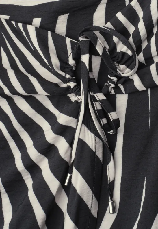 Tissu noir et blanc à motif zèbre avec cordon noué à la taille.