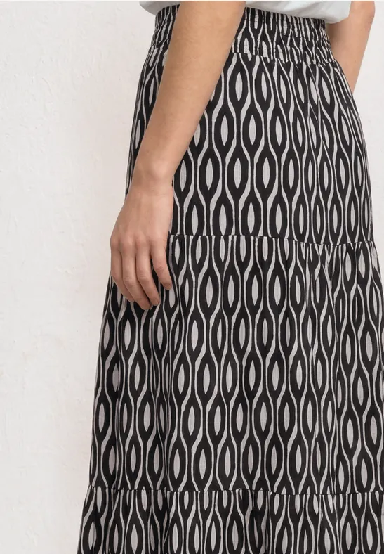 Zwart-witte midirok met golvend ovaal patroon en elastische tailleband.