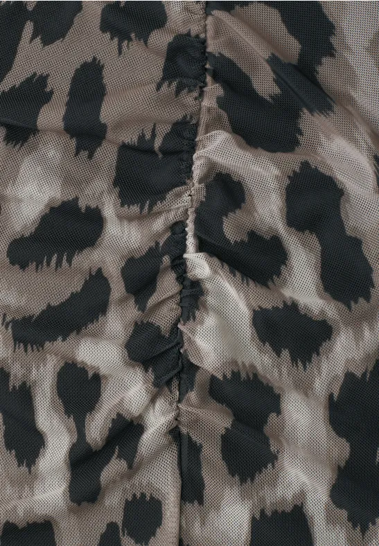 Nahaufnahme eines Stoffs mit Leopardenmuster in Beige und Schwarz, mittige Naht sichtbar.