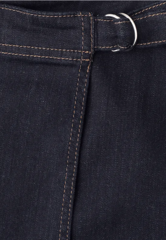 Gros plan sur un tissu denim bleu foncé avec couture contrastante et boucle en D à la taille.