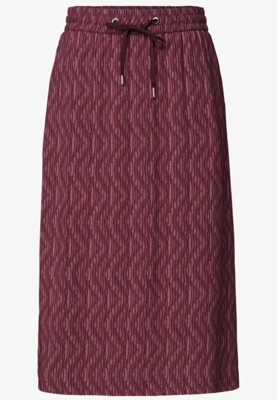 Jupe midi en maille bordeaux, motif chevrons discret, cordon ajustable à la taille.