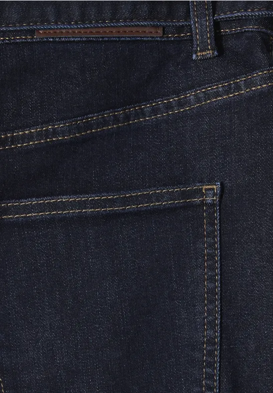 Close-up van een donkerblauwe spijkerbroek, detail van de achterzak met gele stiksels.