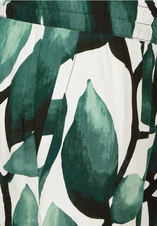 Hose mit grünem Blätterprint, sichtbarer Bund und Seitentasche.