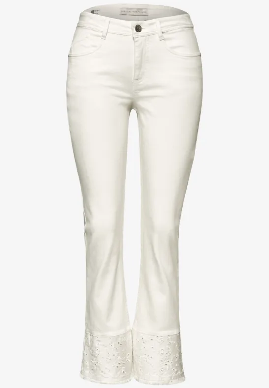 Weiße Jeanshose mit leicht ausgestellt geschnittenem Bein und Spitzendetails am Saum.