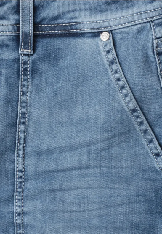Gros plan sur un jean bleu clair montrant la poche, la couture et le passant de ceinture.