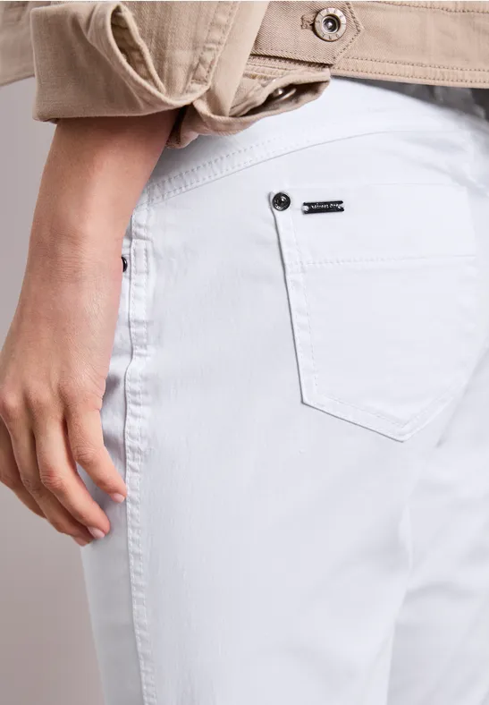 Detailaufnahme einer Person von hinten in weißen Jeans mit Hand an der Hüfte.