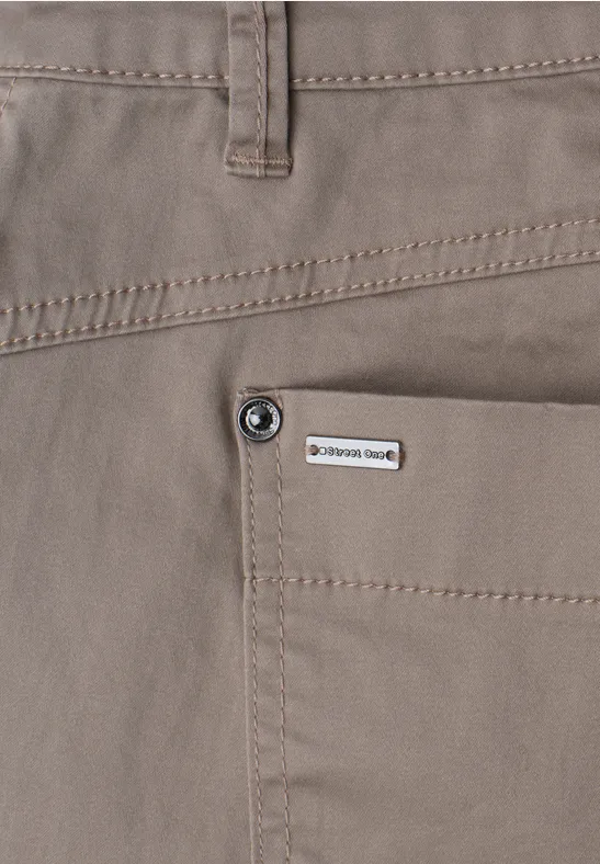 Vue rapprochée d’un pantalon beige avec poche plaquée, bouton et petit label marque