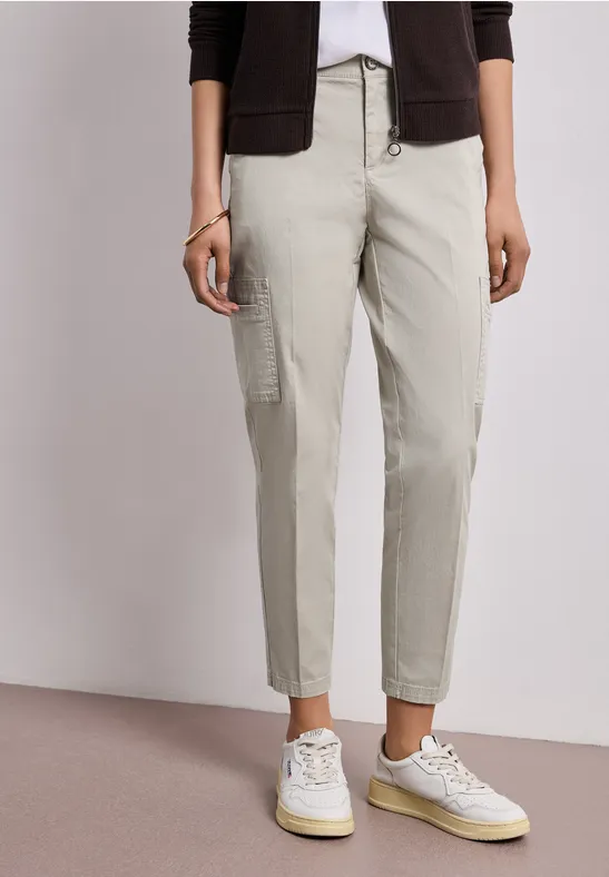 Beige cargobroek met zijzakken, gecombineerd met witte sneakers.