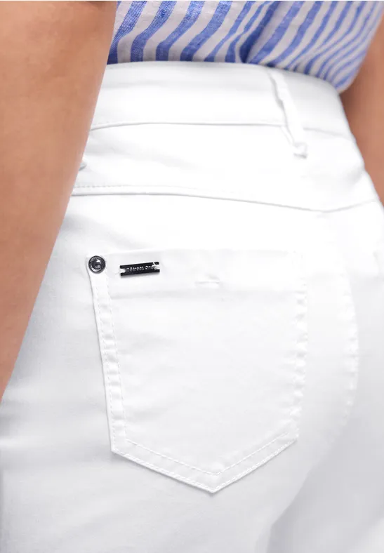 Close-up van een witte spijkerbroek met een blauw-wit gestreept shirt, nadruk op de achterzak.