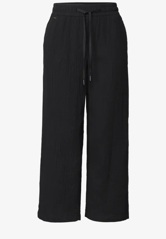 Zwarte, wijdvallende broek met elastische taille en koord, gestructureerde stof, rechte pijpen.