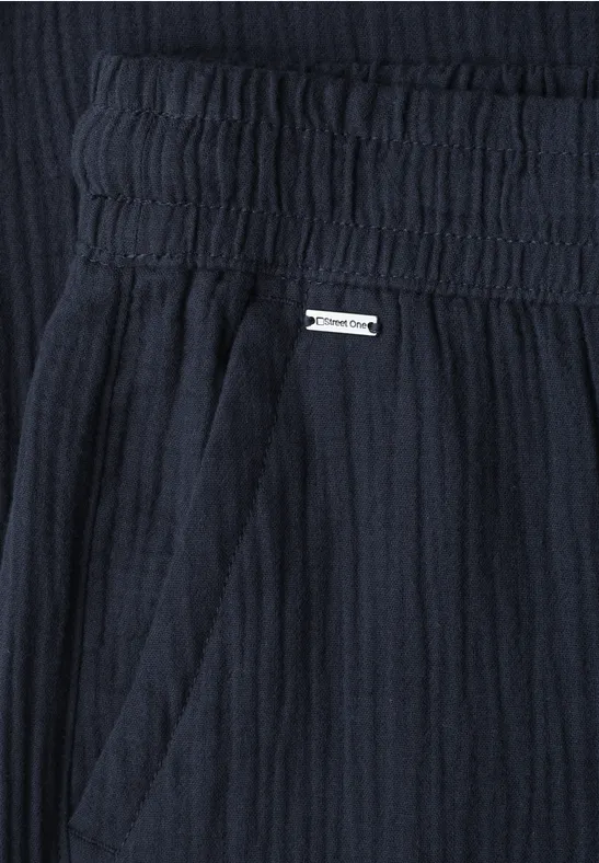 Donkerblauwe, licht gestructureerde stof met elastische taille, zijzak en klein metalen label
