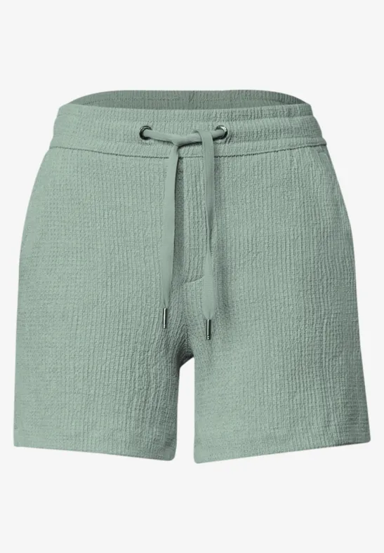 Short court en maille vert sauge avec taille élastique et cordon de serrage.