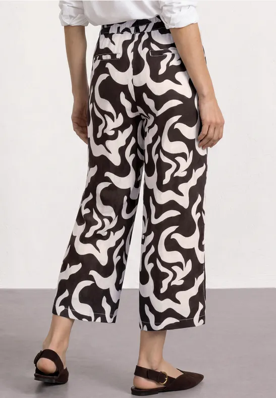 Wijde culottebroek in zwart-wit met abstracte swirlprint, losvallend tot net boven de enkels.