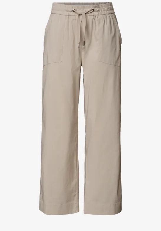 Lichtbeige linnen broek met wijd model, tailleband met koord en opgestikte zakken.