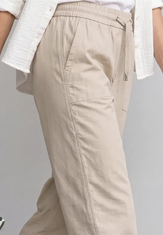 Lichte beige linnen broek met trekkoord en zijzakken.