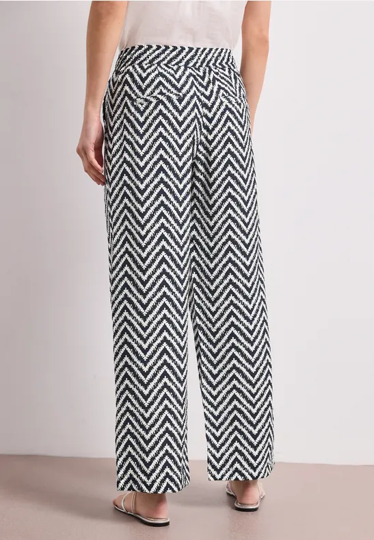 Luchtige zwarte-witte zigzagbroek met hoge taille en wijde pijpen.
