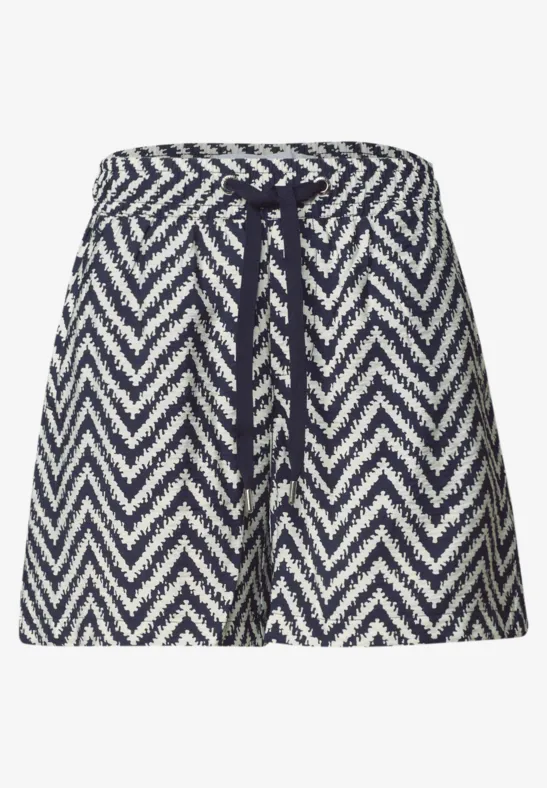 Kort gebreide rok in marineblauw-wit zigzagpatroon, met taillekoord voor verstelbare pasvorm.