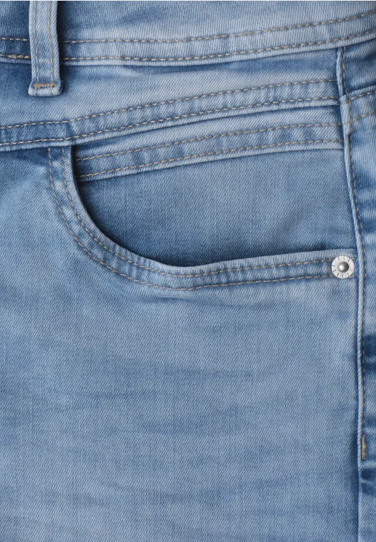 Close-up van een lichtblauwe spijkerbroek met zichtbare voorzak
