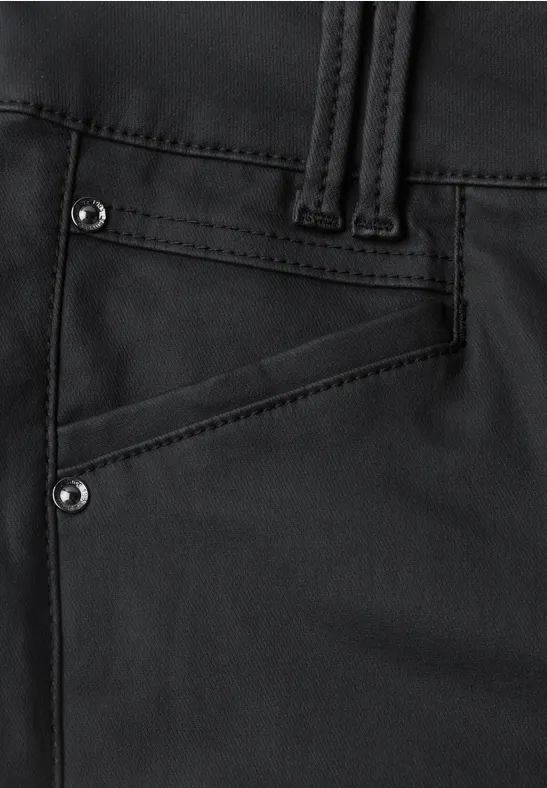 Naheinstellung einer schwarzen Hose mit schräger Tasche und sichtbaren Nieten
