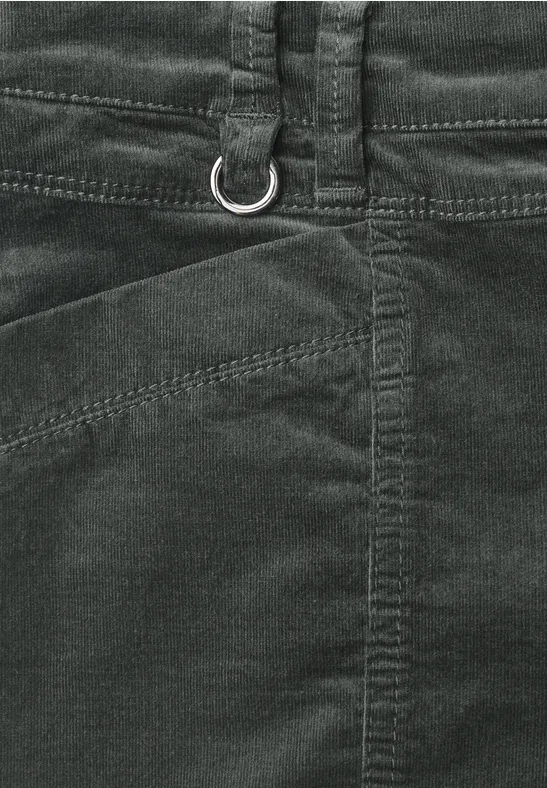 Gros plan d'un pantalon en velours côtelé vert foncé avec passants et anneau en D à la taille.