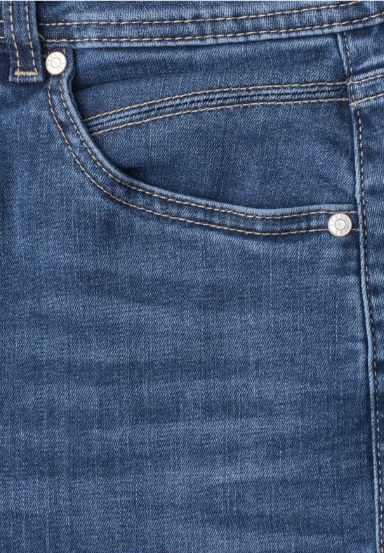 Close-up van een blauwe spijkerbroekzak met zichtbare stiksels en metalen knopen.