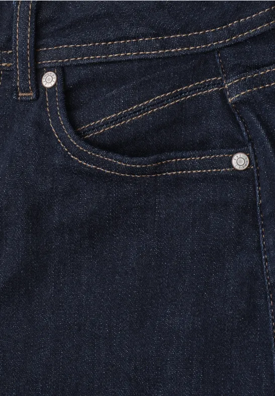 Close-up van een donkerblauwe spijkerbroek met zichtbare zak en stiksels.
