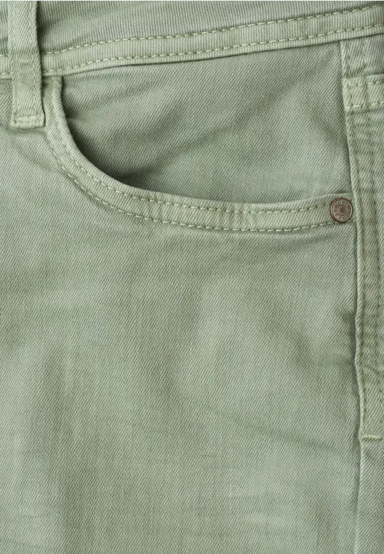 Detailaufnahme einer hellgrünen Jeanshose mit Taschennaht und Metallniete.