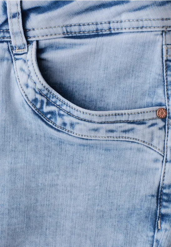 Gros plan sur un jean bleu clair, montrant une poche et un passant de ceinture.