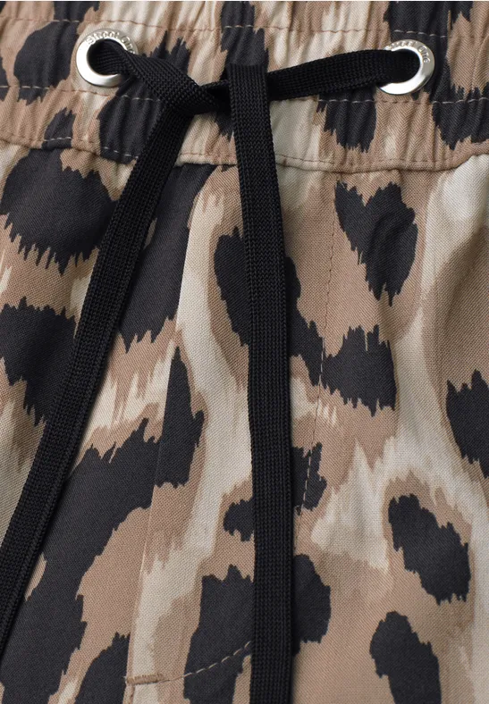Tissu imprimé animal beige et noir, taille élastiquée et cordon noir passant dans des œillets argentés.