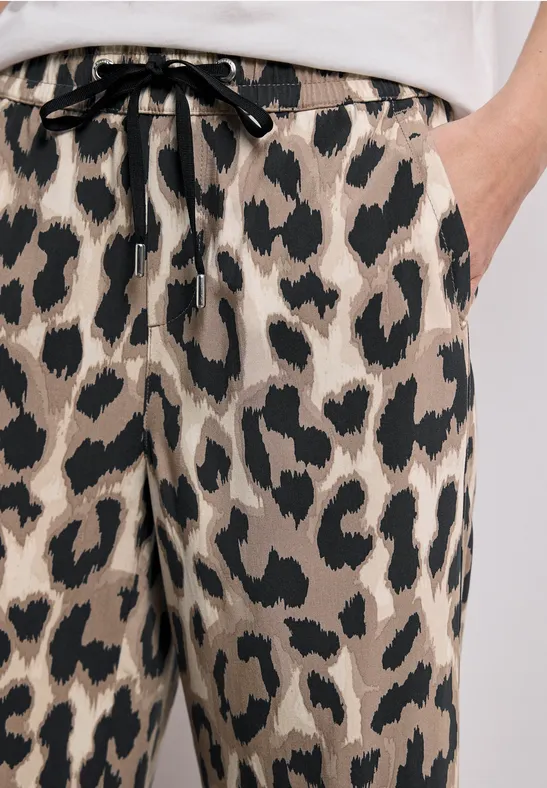 Pantalon beige à motif léopard noir avec cordon à la taille.
