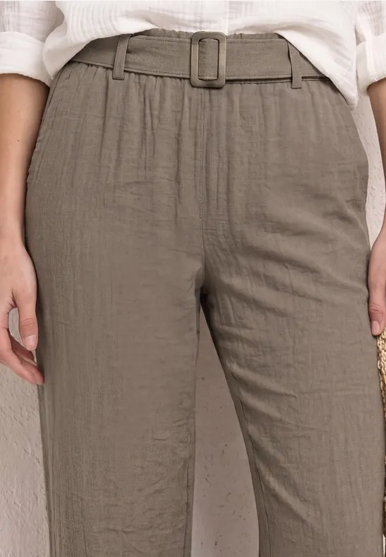 Lichtbruin linnen broek met hoge taille en riem, gecombineerd met een wit topje.