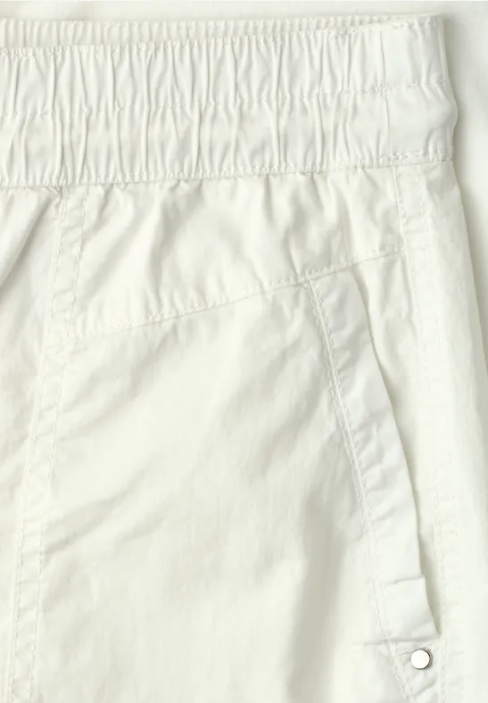 Gros plan d'un pantalon blanc avec taille élastique et poche latérale à pression.