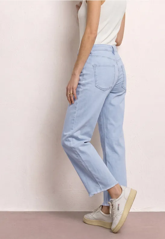 Vue latérale d'une femme portant un jean droit taille haute bleu clair.