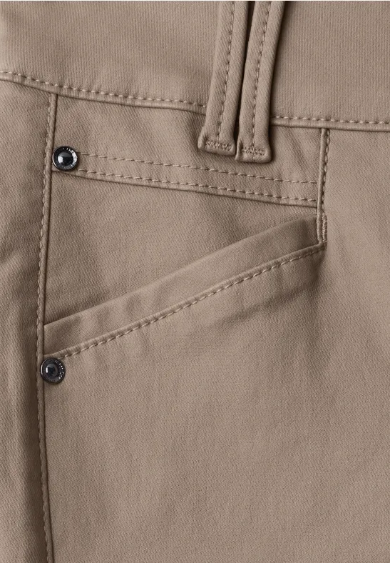 Nahaufnahme einer beigen Hose mit schräger Tasche und Nieten